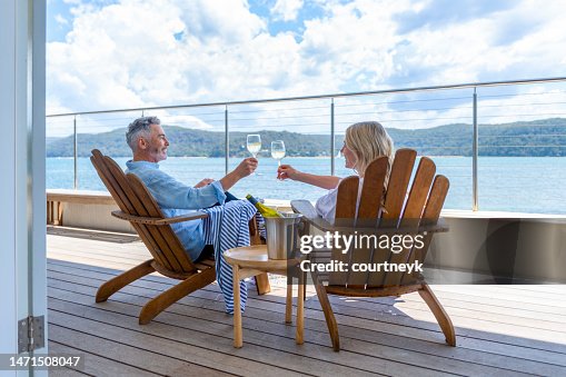 Mature couple drinking wine out on the deck. Mature couple drinking wine out on the deck.