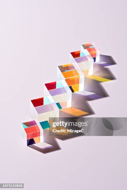 transparent cube prisms in a row refracting colorful light - prisma stockfoto's en -beelden