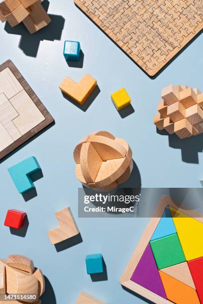 wooden puzzle toys flat lay on blue - tangram foto e immagini stock