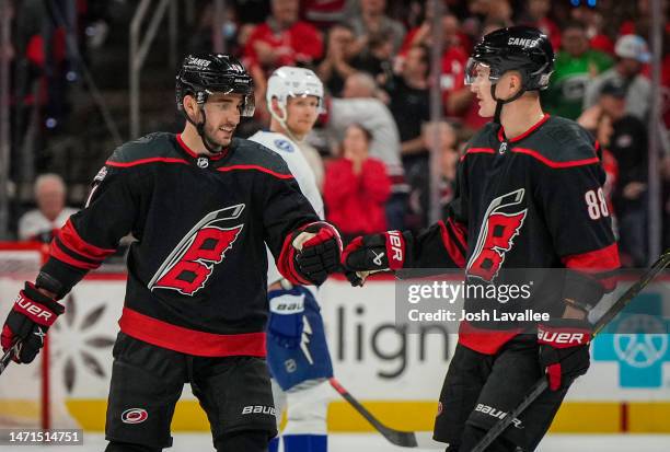 Shayne Gostisbehere of the Carolina Hurricanes celebrates with Martin Necas after a goal during the second period against the Tampa Bay Lightning at...