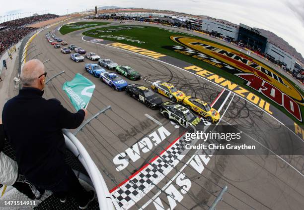 Joey Logano, driver of the Pennzoil Ford, leads the field to t the green flag to start the NASCAR Cup Series Pennzoil 400 at Las Vegas Motor Speedway...