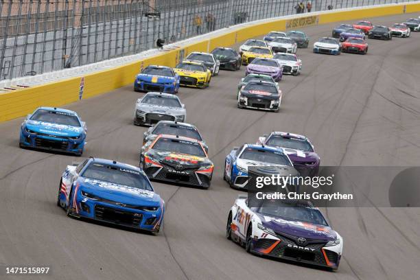Denny Hamlin, driver of the FedEx Express Toyota, and Kyle Larson, driver of the HendrickCars.com Chevrolet, race during the NASCAR Cup Series...