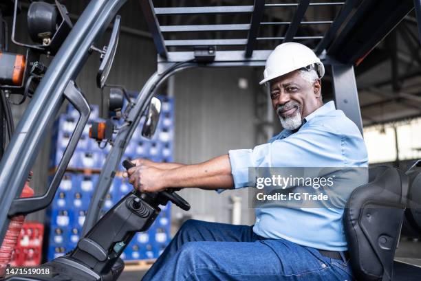 portrait of a senior man in a forklift in a warehouse - working seniors stock pictures, royalty-free photos & images