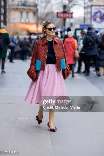 Jenny Walton wears pink pleated skirt, red zipper jacket, pointed heels outside Hermes during Paris Fashion Week - Womenswear Fall Winter 2023 2024 :...