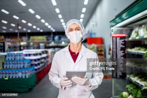 portrait of a mature female inspector using digital tablet in the supermarket - food and drug administration stock pictures, royalty-free photos & images