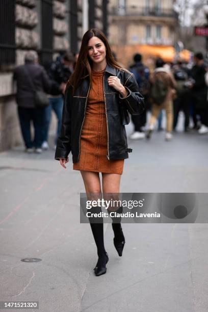 Gala Gonzalez wears a tan suade mini dress, black leather jacket, black socks and black heels, outside Hermes, during Paris Fashion Week - Womenswear...