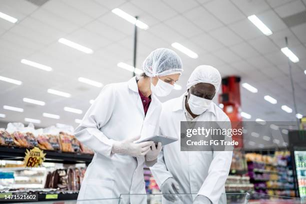 inspecteurs analysant la nourriture dans le supermarché - food and drug administration photos et images de collection