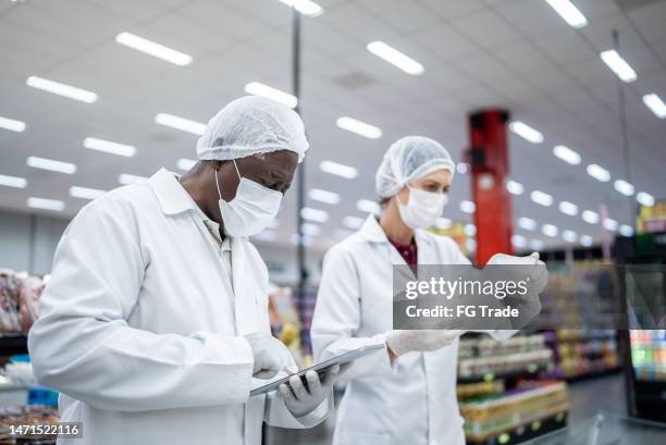 inspectors analyzing the food in the supermarket - voedselveiligheid stockfoto's en -beelden