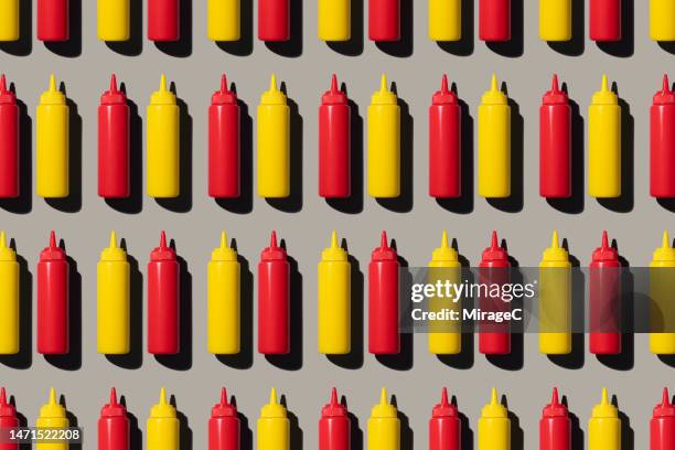 ketchup and mustard bottles repetition pattern - moutarde assaisonnements et vinaigrettes photos et images de collection