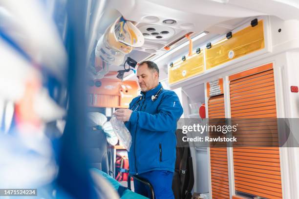 nurse preparing medical supplies in an ambulance - paramedic photos et images de collection