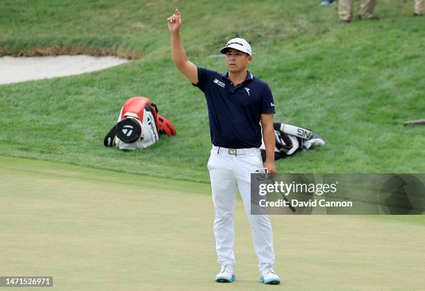 Kurt Kitayama of The United States salutes the crowds as his long putt came to rest less than an inch from the hole on the 18th green to secure his...