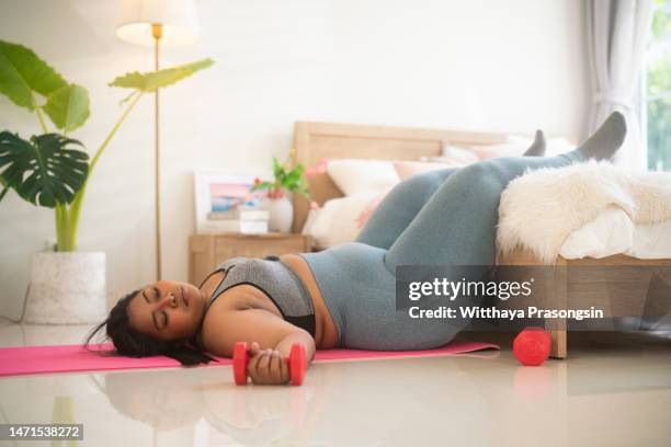 funny overweight sportsman lying down exhausted - fat woman funny stockfoto's en -beelden