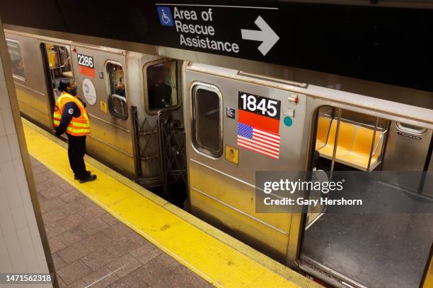 An MTA employee talks with a subway train conductor at the South Ferry station on March 5 in New York City.