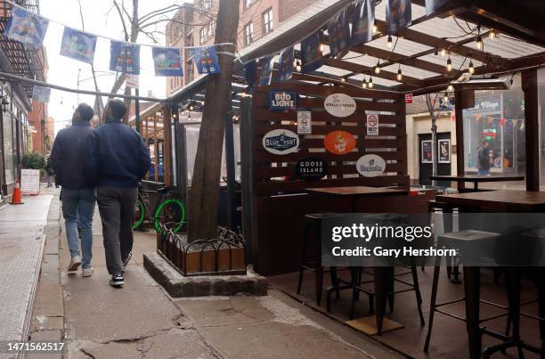 People walk past an empty restaurant outdoor dining shed on Christopher Street in the West Village on March 5 in New York City.
