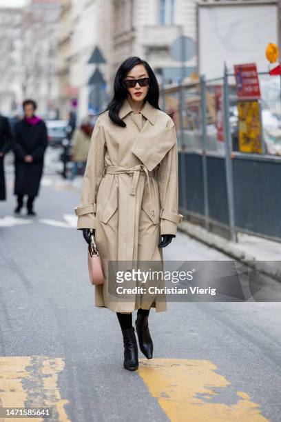 Chriselle Lim wears beige trench coat, black gloves, rose bag, boots outside Lanvin Paris Fashion Week - Womenswear Fall Winter 2023 2024 : Day Seven...