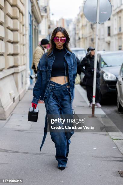 Isabella Charlotta Poppius wears denim jacket, jeans, black cropped top, bag, red gloves, pink sunglasses outside Ottolinger Paris Fashion Week -...