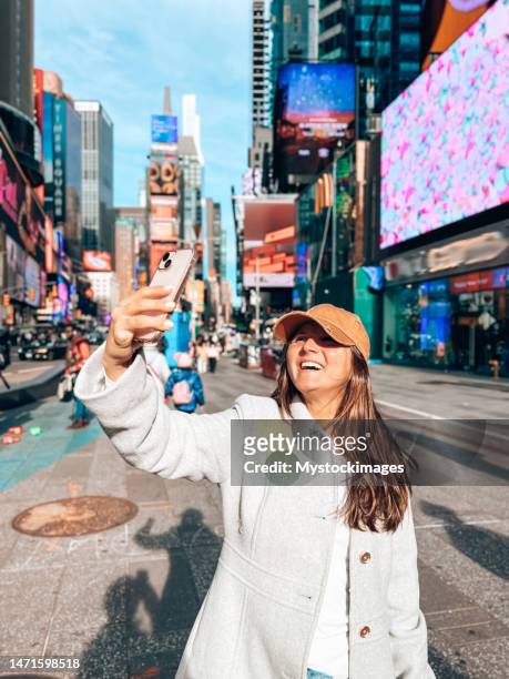junge frau macht selfie am time square, nyc - time square new york stock-fotos und bilder