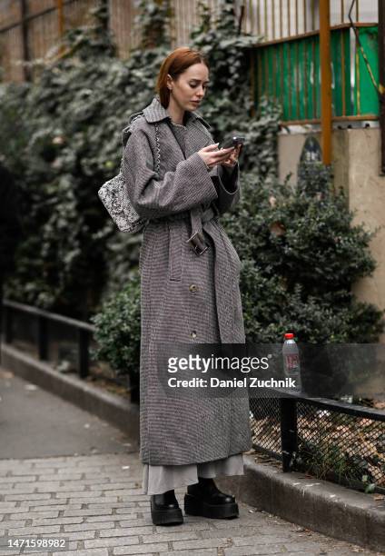Tiernan Cowling is seen wearing a gray coat, black shoes and Chanel bag outside the Akris show during Paris Fashion Week F/W 2023 on March 05, 2023...