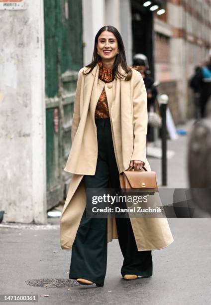 Julia Haghjoo is seen wearing a yello coat, brown floral top, green pants and brown bag outside the Akris show during Paris Fashion Week F/W 2023 on...