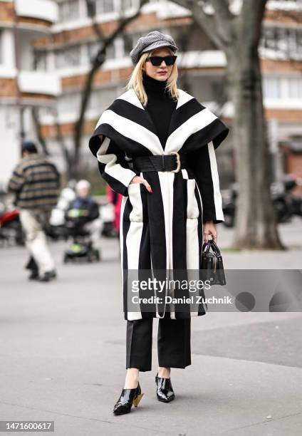 Samantha Angelo is seen wearing a black and white stripe coat, black sweater, black pants, Christian Louboutin heels with a black Chanel bag outside...