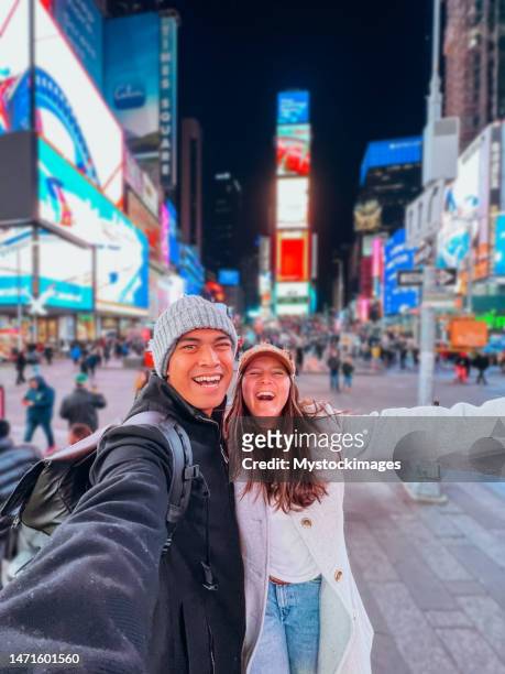 couple taking selfie at time square - new york trip stock pictures, royalty-free photos & images