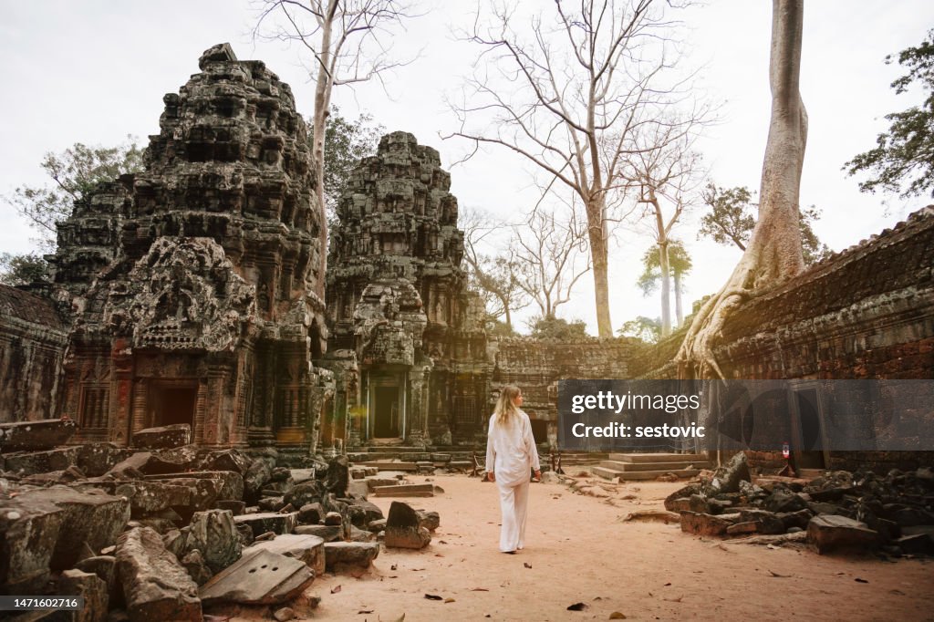 Viajante explorando ruínas antigas do templo de Ta Prohm em Angkor