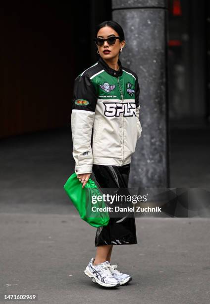 Guest is seen wearing a black, green and white biker jacket, black skirt, green bag and Asics sneakers outside the Palm Angels show during Paris...