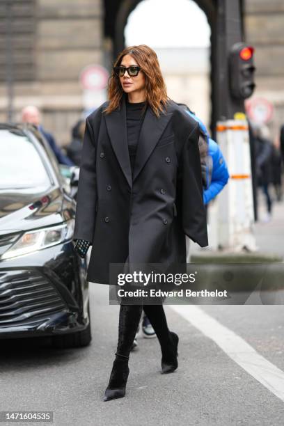 Christine Centenera wears black sunglasses, a black tube short dress, a black oversized blazer jacket, black velvet pointed heels legging tights-high...