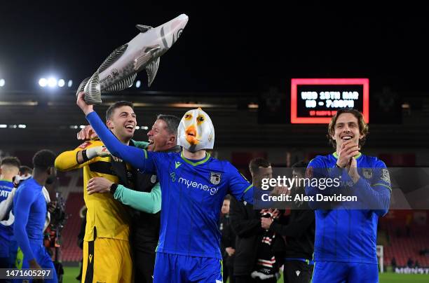 Anthony Driscoll-Glennon of Grimsby Town celebrates victory by wearing a fish mask with teammates at full time following the Emirates FA Cup Fifth...