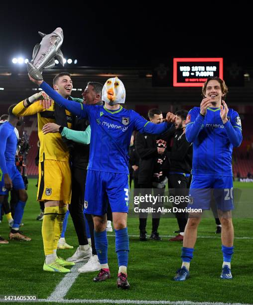 Anthony Driscoll-Glennon of Grimsby Town celebrates victory by wearing a fish mask with teammates at full time following the Emirates FA Cup Fifth...