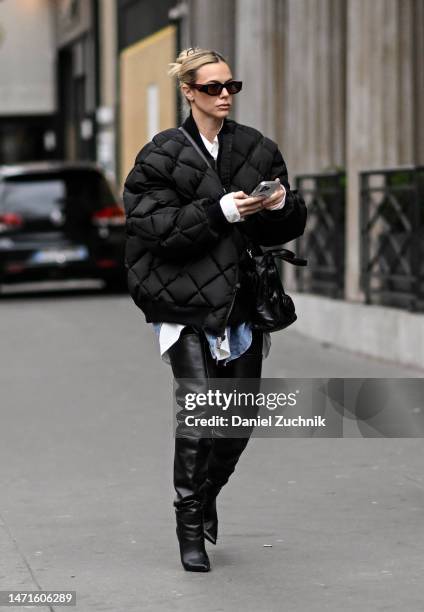 Guest is seen wearing a black puff jacket, black thigh high boots and Prada sunglasses outside the Palm Angels show during Paris Fashion Week F/W...