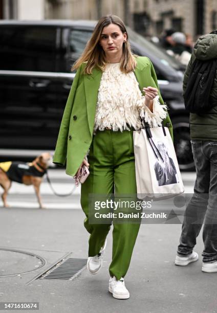 Guest is seen wearing a green jacket, green pants and faux fur cream sweater with white sneakers outside the Palm Angels show during Paris Fashion...