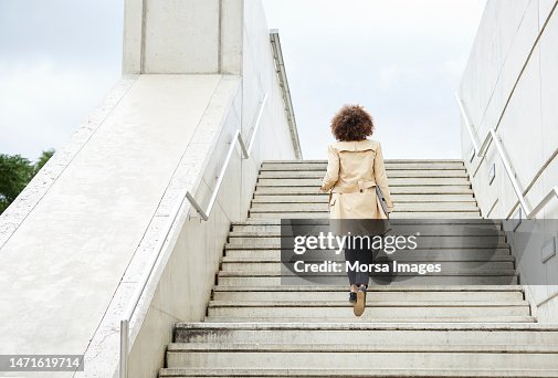 Full length of businesswoman moving up steps