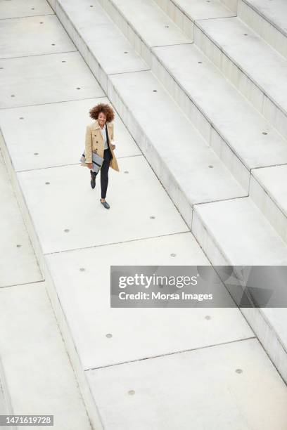 high angle view of businesswoman walking on steps - high angle view walking stock pictures, royalty-free photos & images