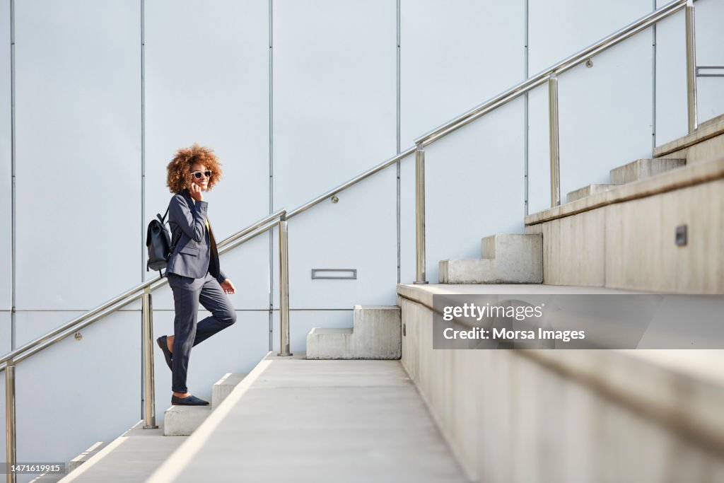 Businesswoman using smart phone on steps