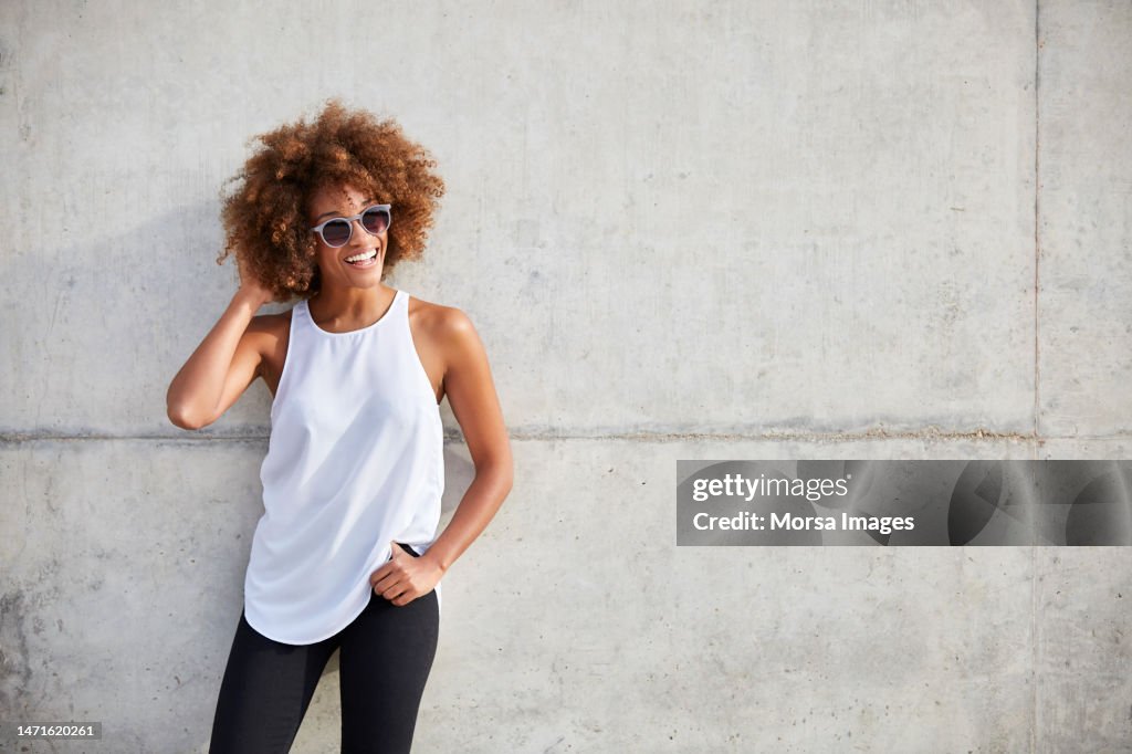 Happy woman wearing tank top and sunglasses