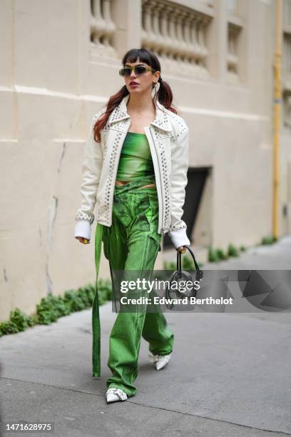 Guest wears green sunglasses, a green and dark green tie and dye print pattern denim shoulder-off / cropped top, asymmetric high waist matching green...