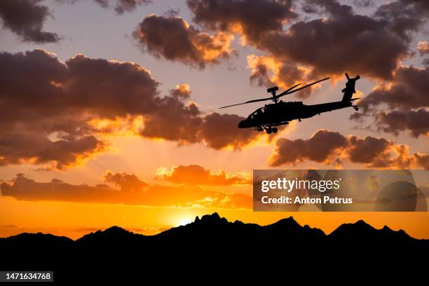 military helicopter on the background of the sunset sky - attack helicopter stock pictures, royalty-free photos & images