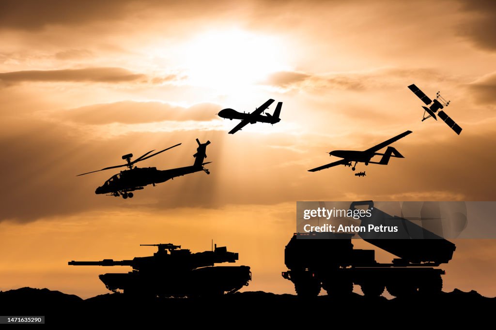 Arms race. Armored tanks, combat drone and missile launcher at sunset.