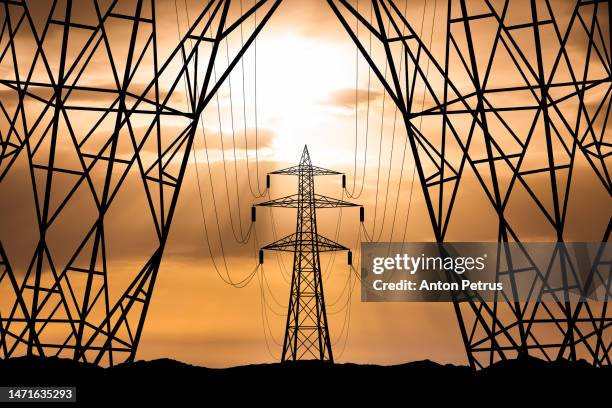 high voltage towers at sunset background. power lines against the sky - mast stockfoto's en -beelden