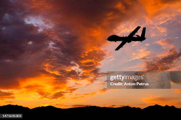 military unmanned aerial vehicle at sunset. combat drone in military conflicts - unmanned aerial vehicle stock pictures, royalty-free photos & images