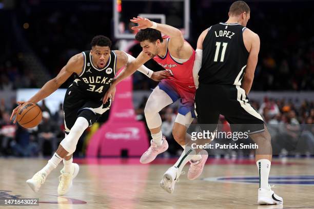 Giannis Antetokounmpo of the Milwaukee Bucks dribbles past Deni Avdija of the Washington Wizards during the second half at Capital One Arena on March...