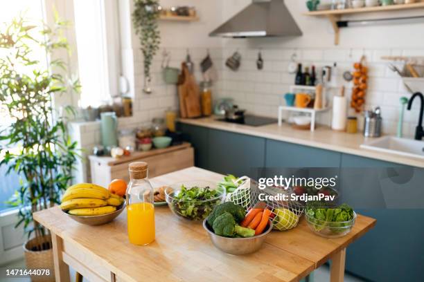 fresh fruit and vegetables on the kitchen island - fruitschaal stockfoto's en -beelden