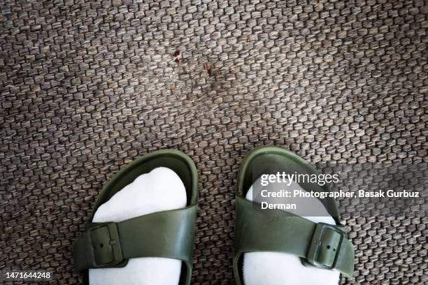 dirt and dust on the furniture indentation marks on the carpet and the feet of a person with slippers - carpet mess stock pictures, royalty-free photos & images