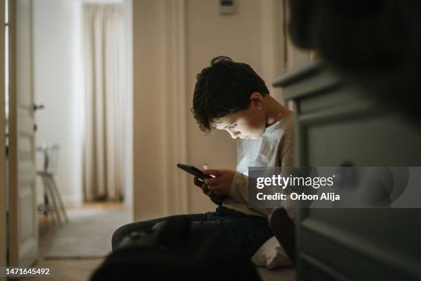 boy playing videogames at home - celular imagens e fotografias de stock