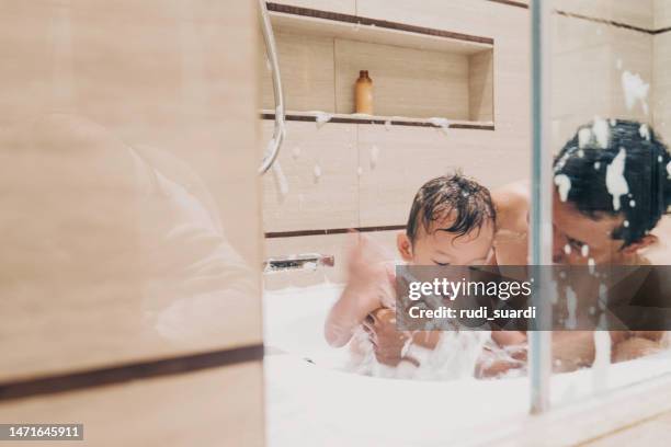 father and little baby boy cleaned in bath - wealthy family inside home stock pictures, royalty-free photos & images