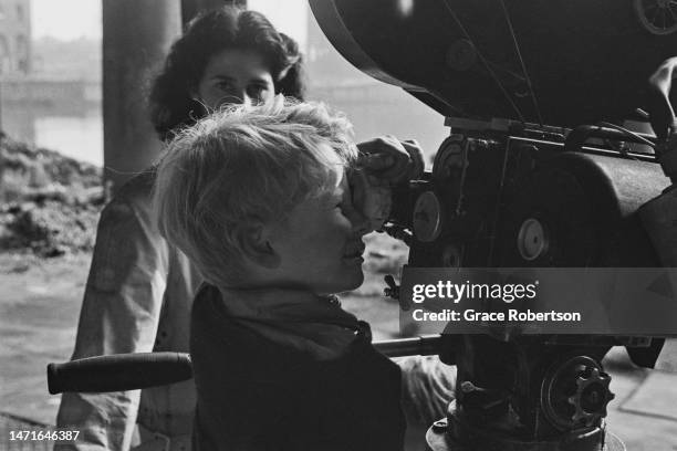 Scottish child actor Jon Whiteley looks through the view finder of a movie camera during production of Charles Crichton's drama, 'Hunted', 1951....