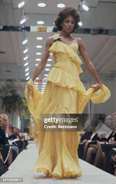 Model wearing a yellow chiffon dress from the spring/summer collection by designer Valentino at a fashion show in Rome, Italy, on February 14th, 1974.