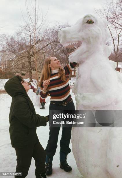 Woman named as Shirley Pugliese and her son Tony put the finishing touches to the snow dinosaur they have built in their front yard in Monsey, New...