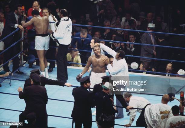 Joe Frazier has his head wiped as Muhammad Ali leans on the ropes in his corner at the end of the twelfth and final round of their fight in New...